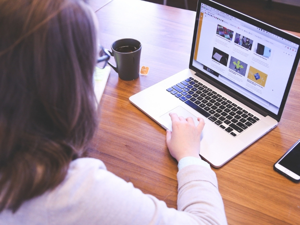 Person using a laptop to browse SEO-related content, with a coffee cup nearby, illustrating user engagement in digital marketing.