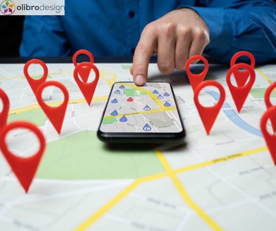 Hand interacting with smartphone displaying a map, surrounded by red location pins, emphasizing local service visibility and optimization for zero-click searches.