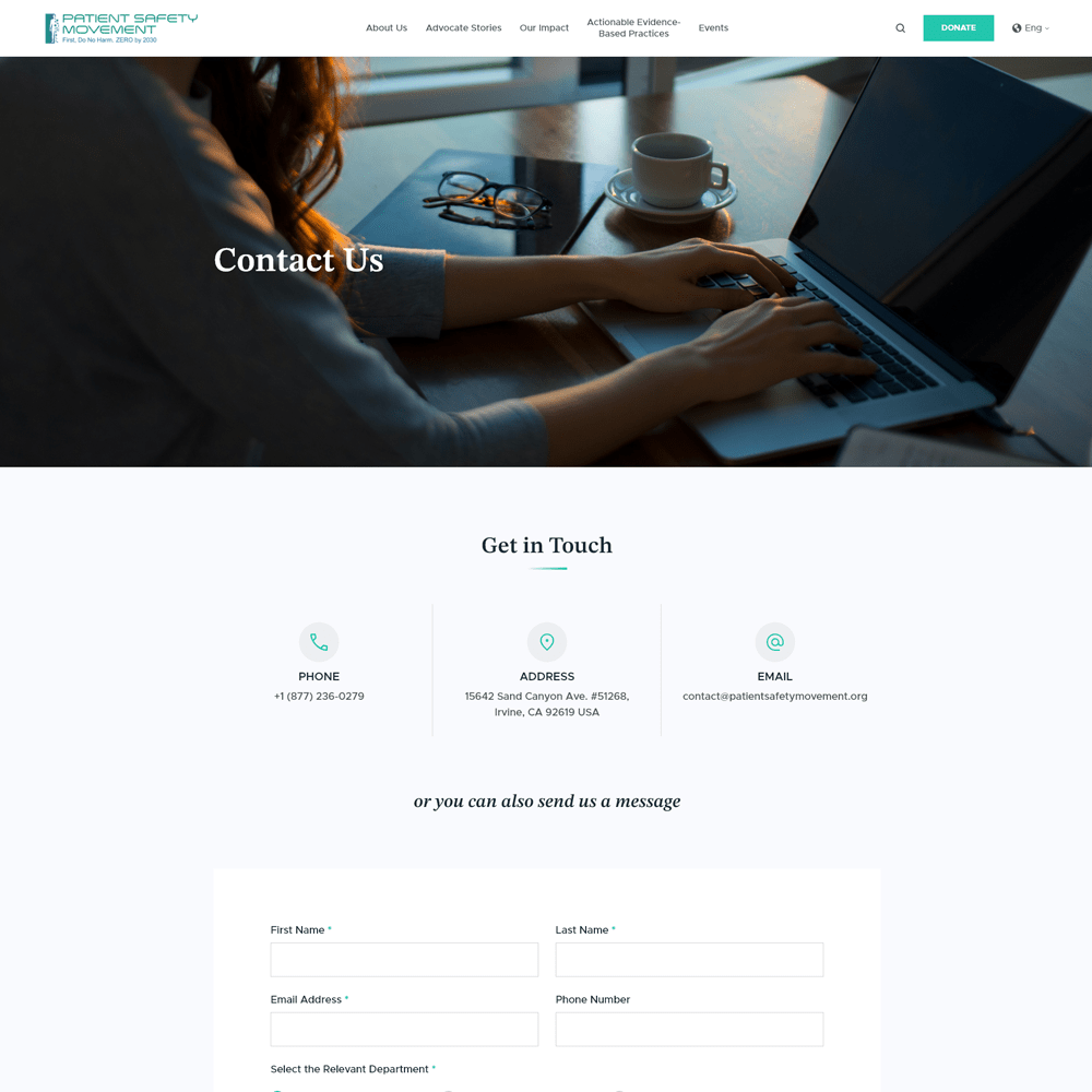 Person typing on laptop at a desk with a coffee cup, representing the Patient Safety Movement Foundation's contact page for inquiries and support.